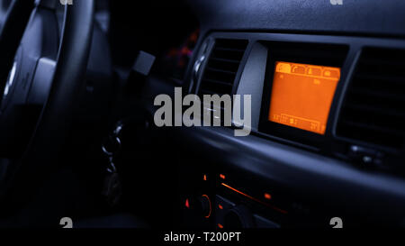 Tasten des Radios, Armaturenbrett, Klimaanlage im Auto close up - schwarz und orange Stockfoto