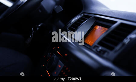 Tasten des Radios, Armaturenbrett, Klimaanlage im Auto close up - schwarz und orange Stockfoto