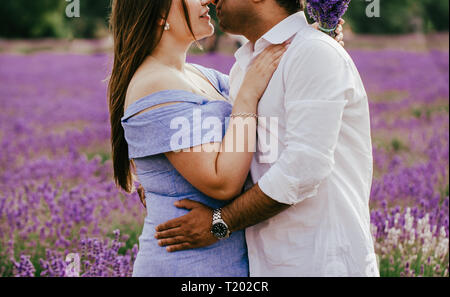 Übergrößen schöne kurvige Frau und asiatischer Mann sind, umarmen und küssen in lavendelfeld. Nahaufnahme von einem Mann und einer Frau. Meyfield Lavendelfeld, England Stockfoto