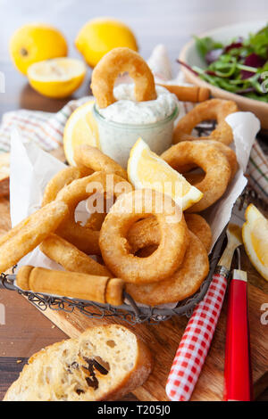 Knusprig paniert calamari Ringe mit Knoblauch dip und Zitrone Stockfoto