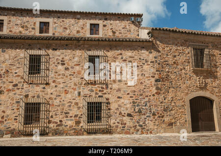 Mittelalterliche Gebäude Fassade, mit Holztür und vergitterten Fenstern in Caceres. Eine charmante Stadt mit einem vollständig erhaltenen Altstadt in Spanien. Stockfoto