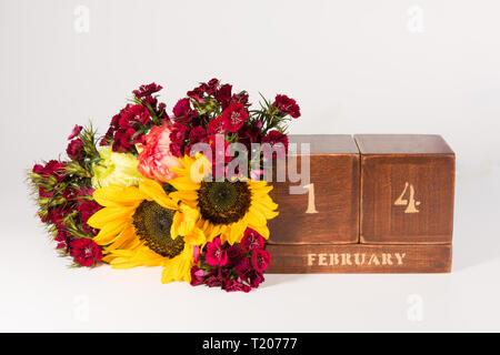 Happy Valentine's Day vintage Holz- Ewiger Kalender für Februar 14 isoliert auf weißem Hintergrund und ein Bündel von verschiedenen Blumen Stockfoto