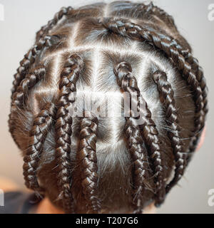 Männer Frisur aus dünnen Zöpfe, kreativen Wellen der Haare auf dem Kopf eines Mannes, Leiter close-up, Haare, kreative Rasieren, Irokesen, Ansicht von oben Stockfoto