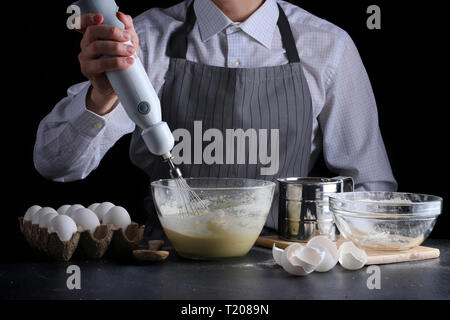 Sichten Mehl in Schüssel. Mann kochen Dessert Konzept. Stockfoto