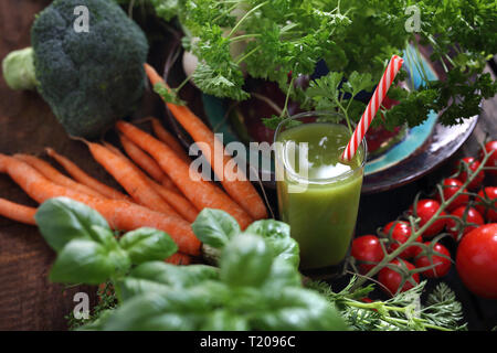Orangensaft aus Gemüse. Gemüse und einem Glas grün frisch gepressten Saft. Stockfoto