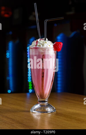 Strawberry Smoothie mit Schlagsahne auf einem Holztisch Stockfoto