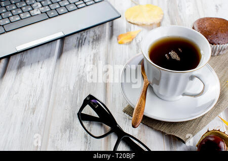 Herbst noch leben. Tea Party Herbst Tag Tasse Kaffee, Kuchen, Nüsse, Blätter, Blumen, Brille und Laptop. Kopieren Sie Platz. Stockfoto