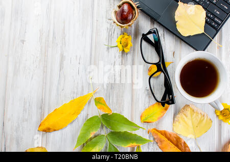 Herbst noch leben. Tea Party Herbst Tag Tasse Kaffee, Kuchen, Nüsse, Blätter, Blumen, Brille und Laptop. Kopieren Sie Platz. Stockfoto