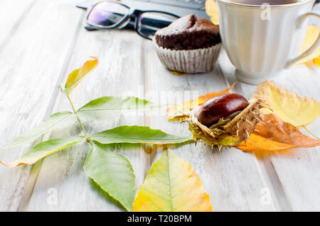 Herbst noch leben. Tea Party Herbst Tag Tasse Kaffee, Kuchen, Nüsse, Blätter, Blumen, Brille und Laptop. Kopieren Sie Platz. Stockfoto