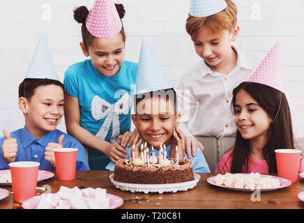 Happy Boy machen möchten, am Geburtstag Kuchen suchen, Party mit Freunden Stockfoto