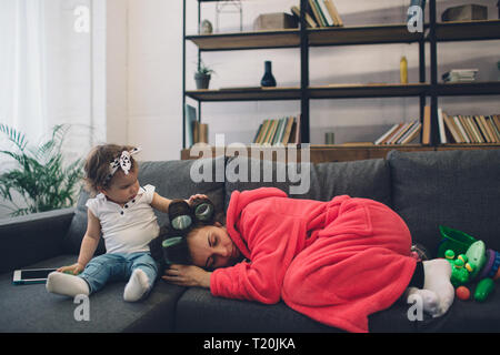 Junge Mutter alte erlebt die postnatale Depression. Traurig und müde Frau mit PPD. Sie will nicht, dass sie mit ihrer Tochter zu spielen. Stockfoto