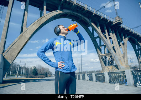 Man Ausruhen nach im City Hintergrund am Morgen läuft. Gesunder Lebensstil Konzept. Stockfoto