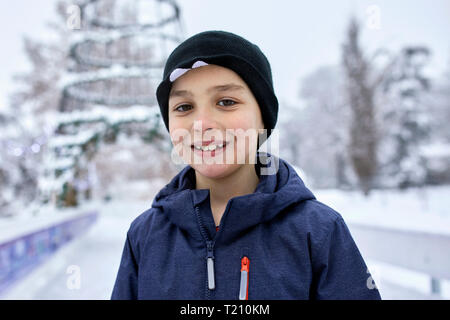 Porträt eines Jungen, tragen Wooly hat, Spaß Eislaufen auf der Eisbahn Stockfoto