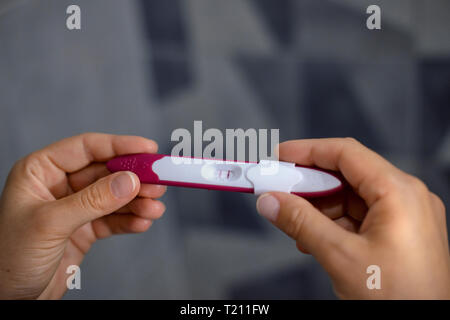 Close-up Woman's Hände, die positiven Schwangerschaftstest Stockfoto