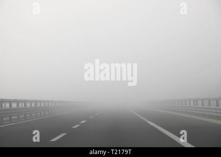 Autobahn mit sehr dichten Nebel gefährlich ohne Autos während der Tage im Winter Stockfoto