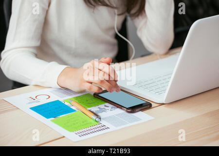 In der Nähe von Frau mit Dokument-, Handy und Laptop auf dem Schreibtisch im Büro Stockfoto