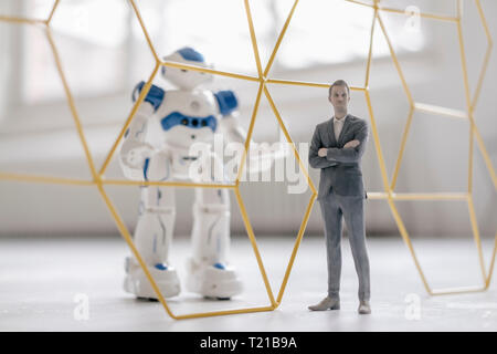 Miniatur Geschäftsmann Figur stand vor der Roboter mit Laptop von der Struktur getrennt Stockfoto