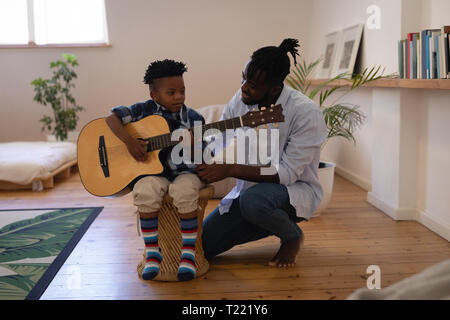 Vater bei seinem Sohn Gitarre zu Hause zu spielen Stockfoto