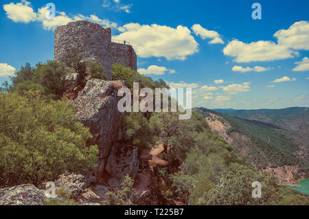 Burg auf der felsigen Klippen an der Monfrague National Park. Burg auf der felsigen Klippen von Bäumen an der Monfrague Nationalpark bedeckt. Stockfoto