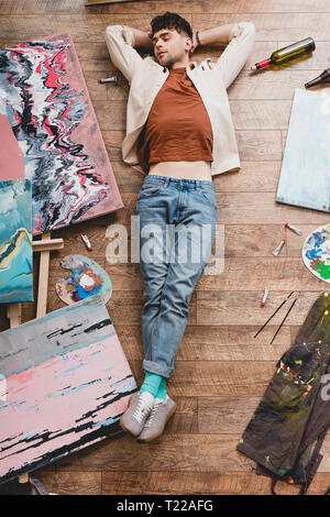 Ansicht von oben auf die Müdigkeit artist schlafen auf dem Boden in der Malerei studio Stockfoto