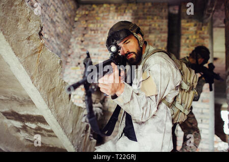 Ein Bild des Menschen Ziel durch das Gewehr Lenz. Er sucht gerade nach vorn. Guy ist ernst und konzentriert. Zwei andere Kerle hinter stehend Stockfoto
