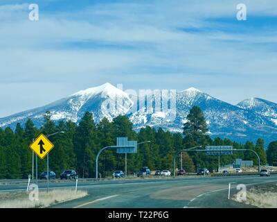 Interstate Highway mit Schnee bedeckten San FranciscoPeaks im Hintergrund, Flagstaff, Arizona, USA Stockfoto