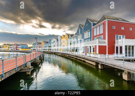 Niederländisch, modernen, farbenfrohen vinex Architektur Häuser am Wasser während der dramatischen und bewölkt, Sonnenuntergang. Houten, Utrecht. Stockfoto