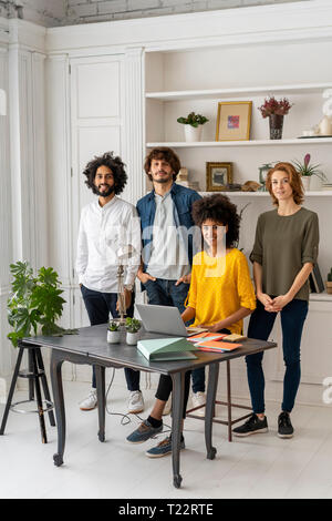 Gruppe von Kreativen stnading in Ihrem neuen Büro Stockfoto