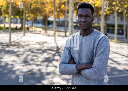 Porträt einer selbstbewussten jungen Mann, stehend in einem Park Stockfoto