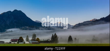 Deutschland, Bayern, Oberallgaeu, Loretto Wiesen in der Nähe von Oberstdorf mit dem morgendlichen Nebel und Berge im Hintergrund Stockfoto