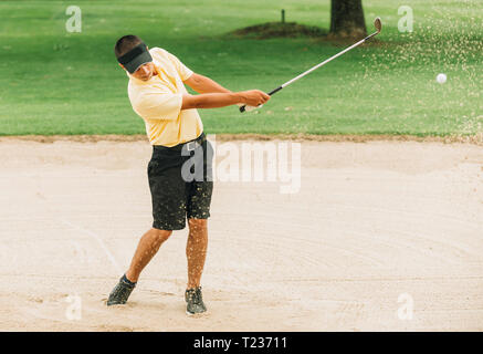 Golfspieler, der von Sandfang. Kugel und der Sand in der Luft eingefroren. Stockfoto