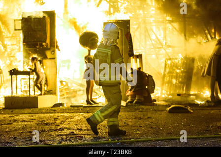 Feuerwehrleute rund um ein Feuer, verursacht durch eine Falla Valenciana Controlling die Flammen des Feuers. Stockfoto