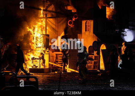 Feuerwehrleute rund um ein Feuer, verursacht durch eine Falla Valenciana Controlling die Flammen des Feuers. Stockfoto