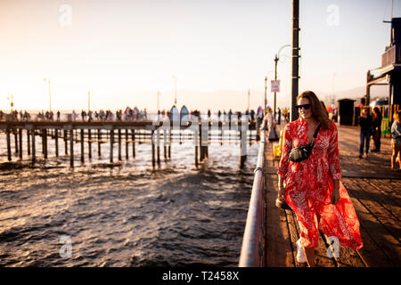 USA, Kalifornien, Santa Monica, lächelnde Frau zu Fuß auf der Pier Stockfoto