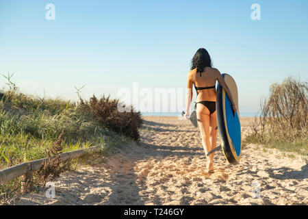 Spanien, Andalusien, Tarifa, Frau gehen mit Stand up Paddle Board am Strand Stockfoto