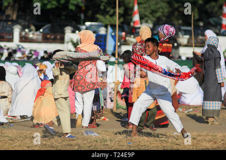 MAUMERE, FLORES/INDONESIEN - 31. AUGUST 2011: Maumere spielen Kinder sarong nach dem Gebet auf dem Feld. Sie sehen glücklich Stockfoto