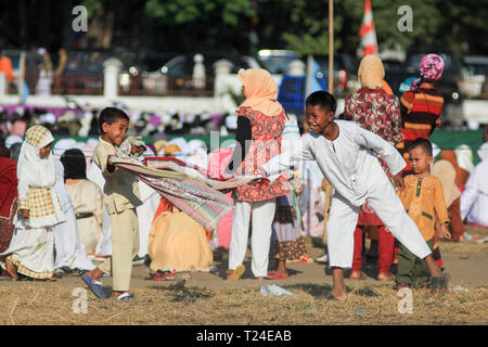 MAUMERE, FLORES/INDONESIEN - 31. AUGUST 2011: Maumere spielen Kinder sarong nach dem Gebet auf dem Feld. Sie sehen glücklich Stockfoto