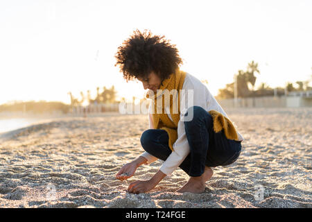 Frau sammeln Muscheln am Strand Stockfoto