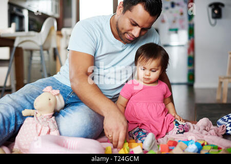 Vater und Baby Mädchen spielen mit Bausteinen zu Hause Stockfoto