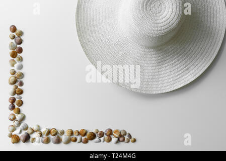 Dekoration Sommer arrangiert von seashells Rahmen und sun Strohhut auf weißem Hintergrund. Stockfoto