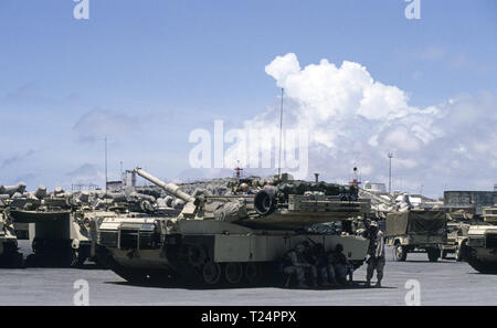 30. Oktober 1993 US-Soldaten Schutz vor der Hitze in den Schatten Ihrer M1A1 Abrams Panzer der 1.BATAILLON der 24 Infanterie Division, 1.BATAILLON der 64th Armored Regiment. Sie haben gerade in den neuen Hafen in Mogadischu, Somalia angekommen. Der Tank ist neben ein paar M 113 APCs geparkt. Stockfoto