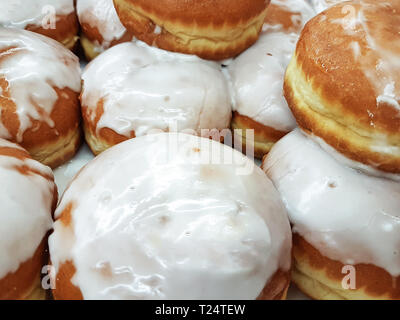 Close-up auf eine Gruppe von frischen Krapfen mit Puderzucker zum Verkauf in einem Lebensmittelgeschäft oder einer Bäckerei Stockfoto