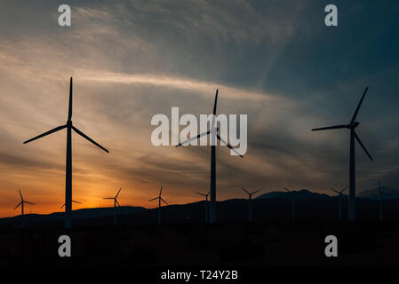 Windmühlen bei Sonnenuntergang, am San Gorgonio Pass Windpark in Palm Springs, Kalifornien Stockfoto