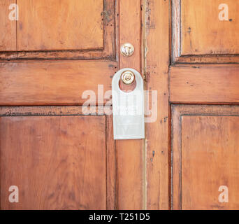 Alte holzgetäfelten Tür mit einem Nicht Stören Schild an die Tür zu tun. Stockfoto