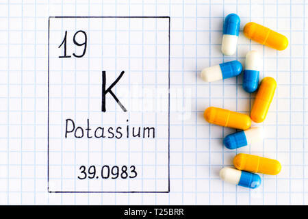 Handschrift chemische Element Kalium K mit Pillen. Close-up. Stockfoto