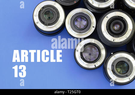 Einige fotografische Objektive und Artikel 13 Inschrift auf blauem Hintergrund. Die europäische Richtlinie zum Urheberrecht einschließlich Artikel 13 wird durch das Europäische p genehmigt Stockfoto