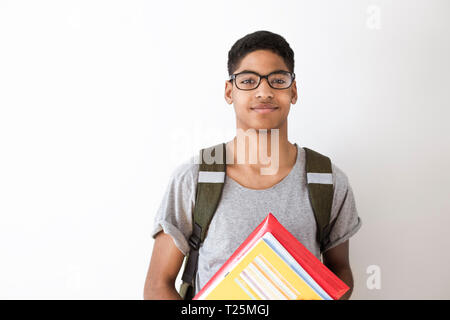 Happy afro-amerikanische Studenten in Gläsern mit Büchern. Porträt eines schwarzen jungen Mann mit Lehrbüchern in seinen Händen. Lächelnde Junge mit einem Rucksack und Notebook Stockfoto