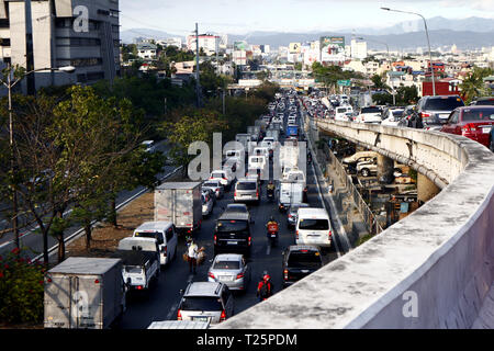 TAGUIG CITY, Philippinen - 28. MÄRZ 2019: Öffentliche und private Fahrzeuge sind in einem Stau entlang einer großen Autobahn stecken und eine Überführung in der Hauptverkehrszeit ho Stockfoto