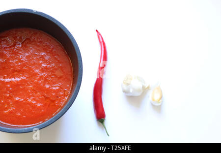 Konzept der italienisches Essen. nach oben Blick auf italienische Tomatensauce, Chili und Knoblauch auf weißem Hintergrund Stockfoto