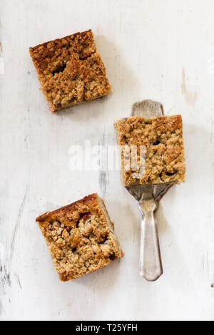 Drei Stücke von Rhabarber Kuchen und einen Kuchen server auf weißem Holz Stockfoto